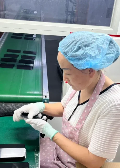 Worker assembling electronics in factory