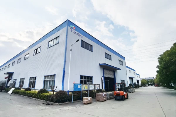 Industrial warehouse exterior with forklift in driveway.
